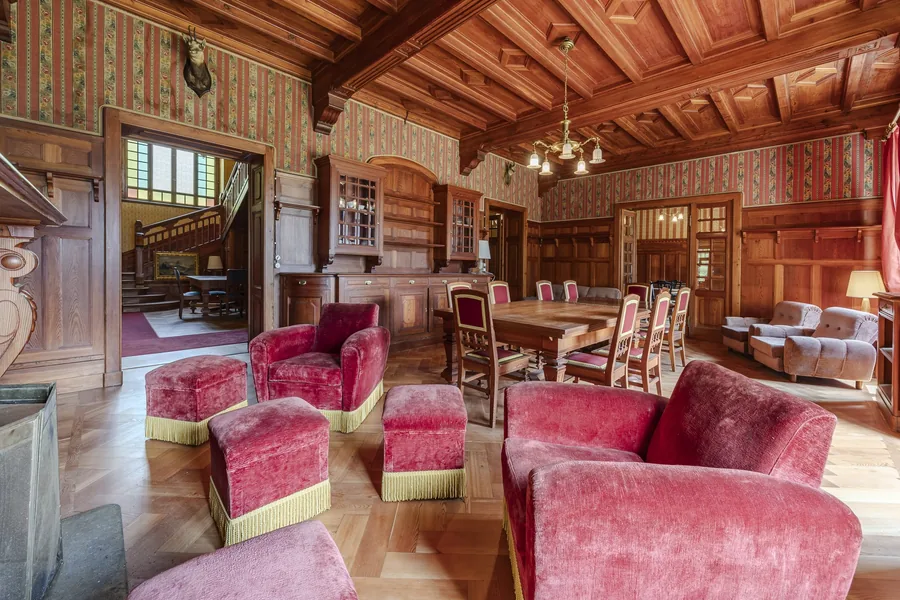 Salon with red armchairs in Villa Laubenò, marketed by Engel & Völkers Private Office